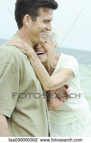 Senior woman leaning against adult son, both laughing, holding hands View Large Photo Image Stock Image - Senior woman leaning against adult son, both laughing, holding hands. Fotosearch