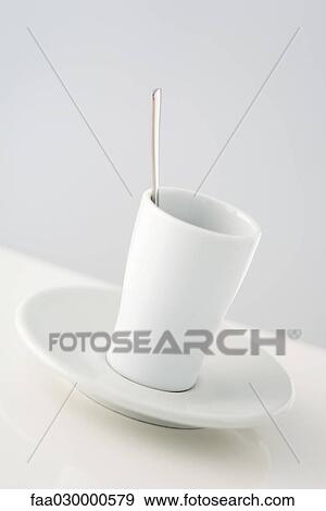 Stock Photo - Spoon in coffee cup on saucer, close-up. Fotosearch