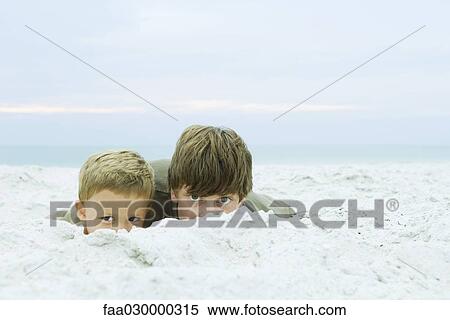 Teen boy and little brother at the beach, peeking over sand at camera View Large Photo Image Stock Photography - Teen boy and little brother at the beach, peeking over sand at camera. Fotosearch
