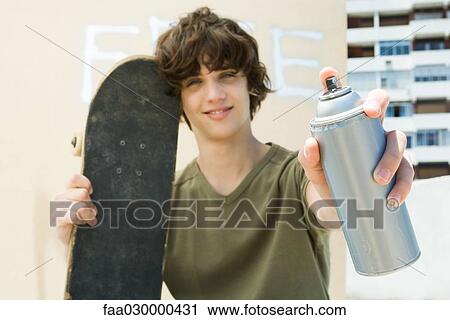 Teen boy holding spray paint can, smiling at camera View Large Photo Image Stock Image - Teen boy holding spray paint can, smiling at camera. Fotosearch