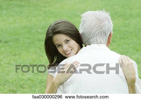 Teen girl embracing grandfather, smiling at camera View Large Photo Image Stock Photograph - Teen girl embracing grandfather, smiling at camera. Fotosearch