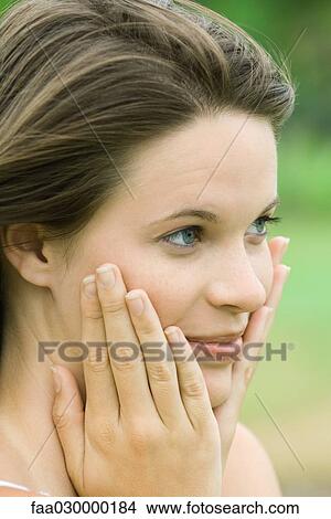 Teen girl holding face in hands, close-up View Large Photo Image Picture - Teen girl holding face in hands, close-up. Fotosearch