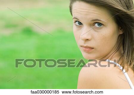 Teen girl looking over shoulder at camera, close-up View Large Photo Image Stock Photography - Teen girl looking over shoulder at camera, close-up. Fotosearch