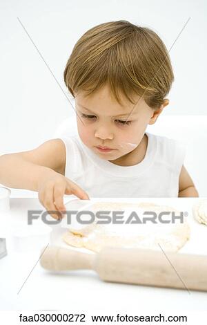 Toddler boy cutting dough with cookie cutter View Large Photo Image Stock Image - Toddler boy cutting dough with cookie cutter. Fotosearch
