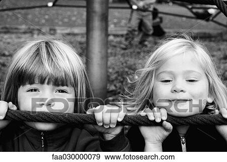Stock Photo - Two girls on playground, looking at camera, close-up, portrait. Fotosearch