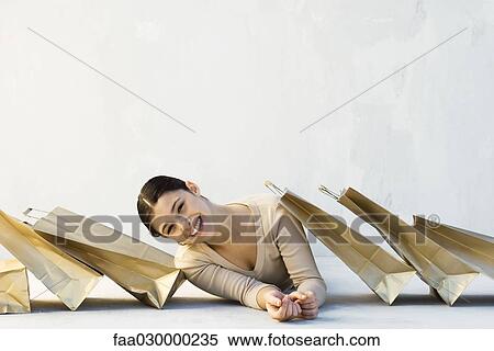Woman among shopping bags, leaning to one side, smiling at camera View Large Photo Image Stock Photography - Woman among shopping bags, leaning to one side, smiling at camera. Fotosearch