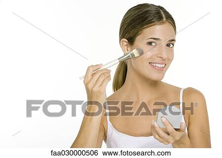 Woman applying blush, holding hand mirror, smiling at camera View Large Photo Image Stock Photograph - Woman applying blush, holding hand mirror, smiling at camera. Fotosearch