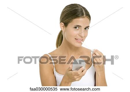 Woman applying lip gloss, smiling at camera View Large Photo Image Stock Photography - Woman applying lip gloss, smiling at camera. Fotosearch
