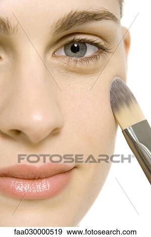 Woman applying make-up to cheek, smiling at camera, close-up View Large Photo Image Stock Photo - Woman applying make-up to cheek, smiling at camera, close-up. Fotosearch
