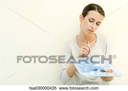 Woman holding artist's palette and paintbrush View Large Photo Image Stock Photography - Woman holding artist's palette and paintbrush. Fotosearch