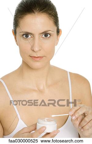 Woman holding cotton swab and jar of moisturizer, looking at camera View Large Photo Image Stock Photography - Woman holding cotton swab and jar of moisturizer, looking at camera. Fotosearch