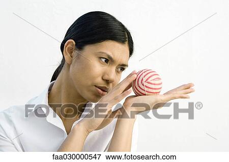 Woman holding striped ball in open palm, looking away View Large Photo Image Stock Photo - Woman holding striped ball in open palm, looking away. Fotosearch