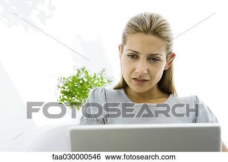 Woman intently looking at laptop, cropped View Large Photo Image Stock Photograph - Woman intently looking at laptop, cropped. Fotosearch