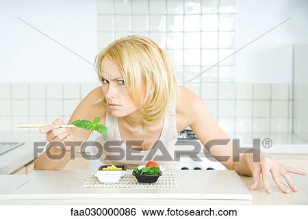 Stock Photograph - Woman leaning over food, looking at camera threateningly. Fotosearch