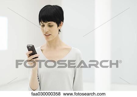 Woman looking at cell phone View Large Photo Image Stock Photo - Woman looking at cell phone. Fotosearch