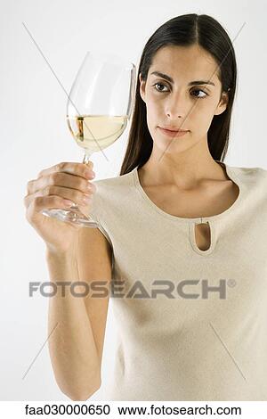 Woman looking at white wine in glass, close-up View Large Photo Image Stock Image - Woman looking at white wine in glass, close-up. Fotosearch