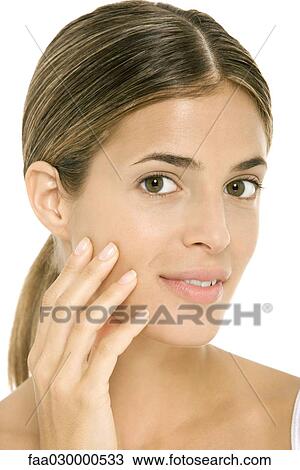 Woman touching cheek, smiling at camera, portrait View Large Photo Image Stock Image - Woman touching cheek, smiling at camera, portrait. Fotosearch