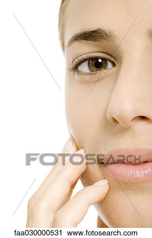 Woman touching face, looking at camera, cropped view View Large Photo Image Stock Image - Woman touching face, looking at camera, cropped view. Fotosearch