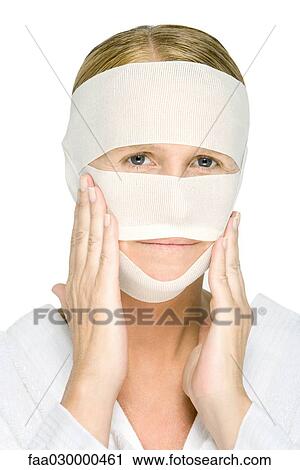 Woman with bandaged face, touching cheeks, looking at camera View Large Photo Image Stock Image - Woman with bandaged face, touching cheeks, looking at camera. Fotosearch