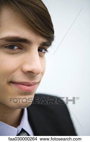 Picture - Young man in suit, smiling at camera, portrait, cropped. Fotosearch