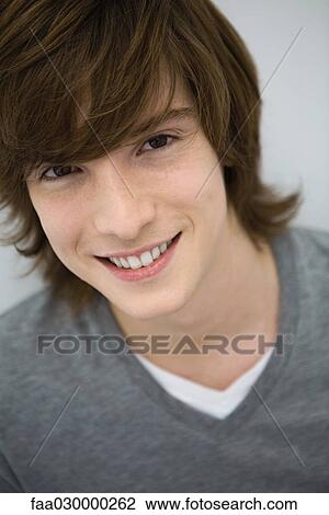 Stock Image - Young man smiling at camera, portrait. Fotosearch