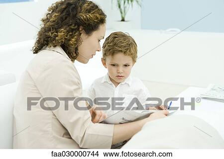 Picture - Young mother reading to little boy. Fotosearch