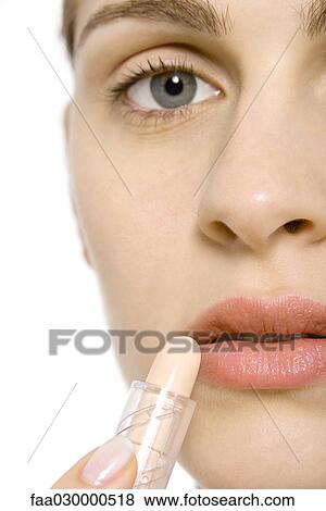 Young woman applying lipstick, cropped view View Large Photo Image Stock Photo - Young woman applying lipstick, cropped view. Fotosearch
