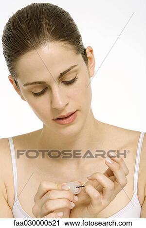 Young woman applying nail polish View Large Photo Image Stock Image - Young woman applying nail polish. Fotosearch