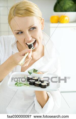 Young woman eating sushi View Large Photo Image Stock Photo - Young woman eating sushi. Fotosearch