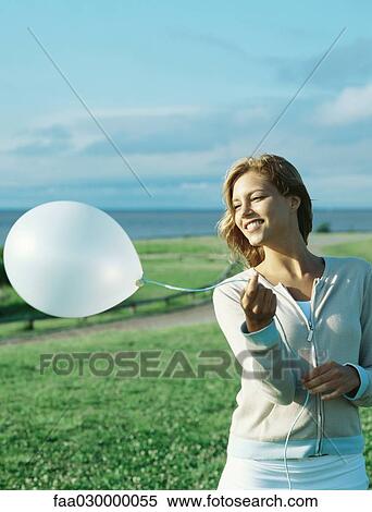 Young woman holding balloon View Large Photo Image Stock Photography - Young woman holding balloon. Fotosearch