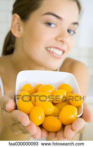 Young woman holding out bowl of yellow cherry tomatoes View Large Photo Image Stock Image - Young woman holding out bowl of yellow cherry tomatoes. Fotosearch
