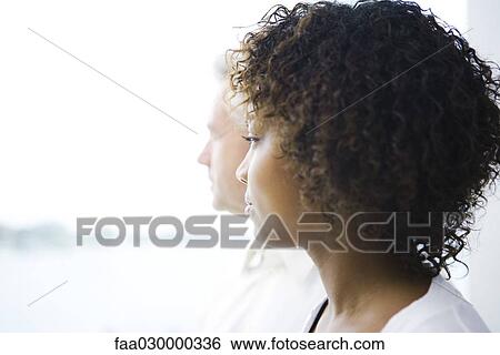 Young woman looking away, man in background View Large Photo Image Stock Photograph - Young woman looking away, man in background. Fotosearch