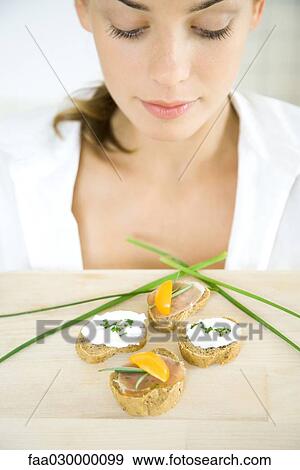 Young woman looking down at canapes View Large Photo Image Stock Photo - Young woman looking down at canapes. Fotosearch