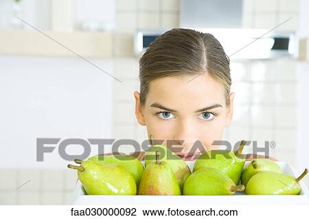 Young woman looking over tray of pears View Large Photo Image Stock Image - Young woman looking over tray of pears. Fotosearch