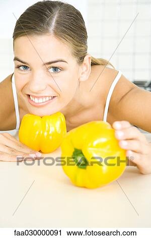 Young woman posing with yellow bell peppers View Large Photo Image Stock Image - Young woman posing with yellow bell peppers. Fotosearch