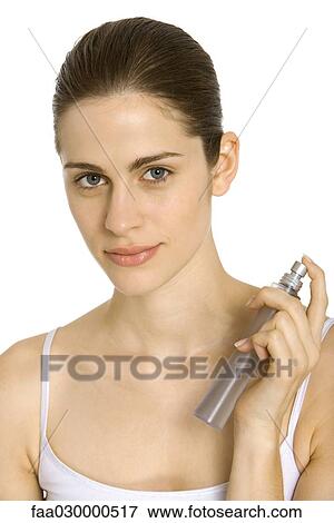 Young woman spraying perfume on neck, smiling at camera View Large Photo Image Stock Photo - Young woman spraying perfume on neck, smiling at camera. Fotosearch