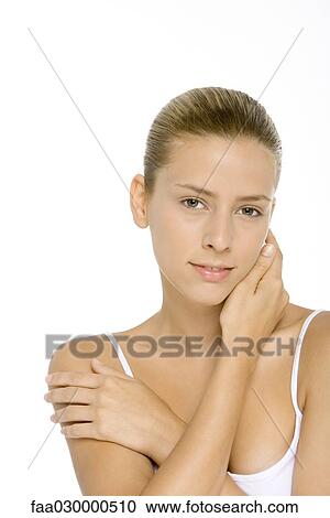 Young woman touching neck and shoulder, smiling at camera View Large Photo Image Stock Image - Young woman touching neck and shoulder, smiling at camera. Fotosearch