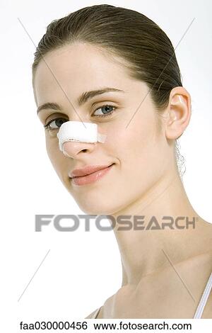 Young woman with bandage on nose, smiling at camera, portrait View Large Photo Image Stock Photograph - Young woman with bandage on nose, smiling at camera, portrait. Fotosearch