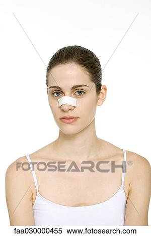 Young woman with bandage on nose, looking at camera, portrait View Large Photo Image Stock Photography - Young woman with bandage on nose, looking at camera, portrait. Fotosearch