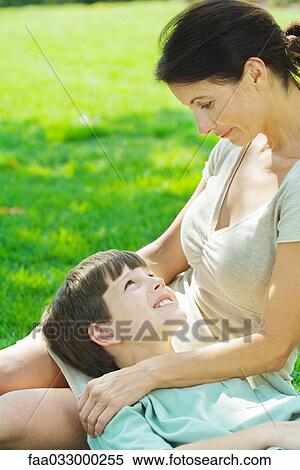Stock Photography - Boy resting head on mother's lap, smiling at each other. Fotosearch