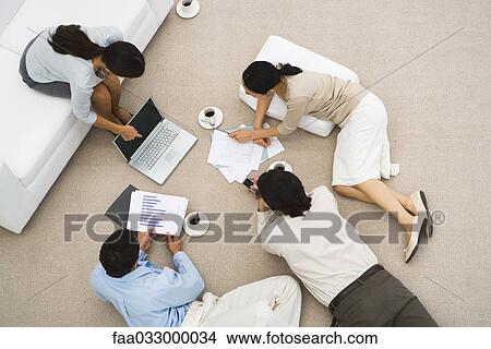 Picture - Business meeting, people reclining on the floor, high angle view. Fotosearch