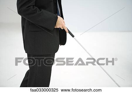 Stock Photography - Businessman walking with white cane, cropped view. Fotosearch