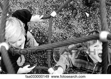 Stock Photo - Children playing on ropes, shouting, one looking at camera, overhead view. Fotosearch