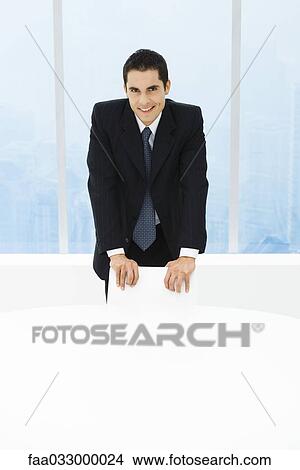 Executive standing behind chair, smiling at camera, portrait View Large Photo Image Picture - Executive standing behind chair, smiling at camera, portrait. Fotosearch