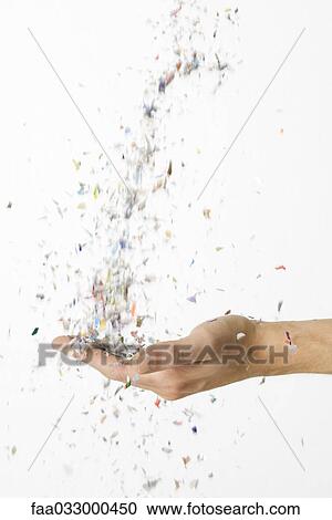Stock Image - Hand catching falling confetti. Fotosearch