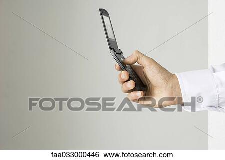 Hand holding cell phone, side view View Large Photo Image Stock Photograph - Hand holding cell phone, side view. Fotosearch