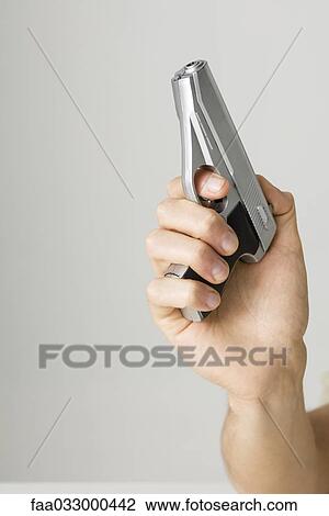 Hand holding gun, close-up View Large Photo Image Stock Image - Hand holding gun, close-up. Fotosearch