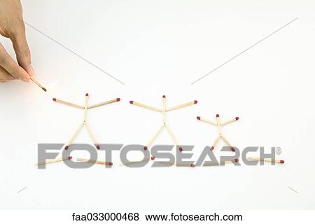 Stock Photo - Hand holding lit match up to unlit matches arranged as stick figures. Fotosearch