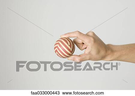 Hand holding striped ball View Large Photo Image Stock Image - Hand holding striped ball. Fotosearch