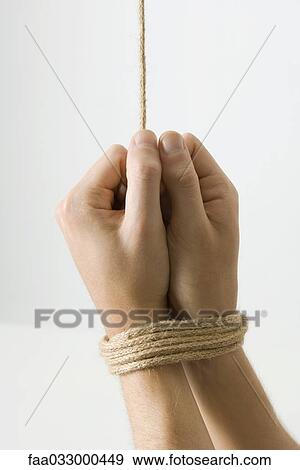 Stock Photo - Hands bound with rope, close-up. Fotosearch